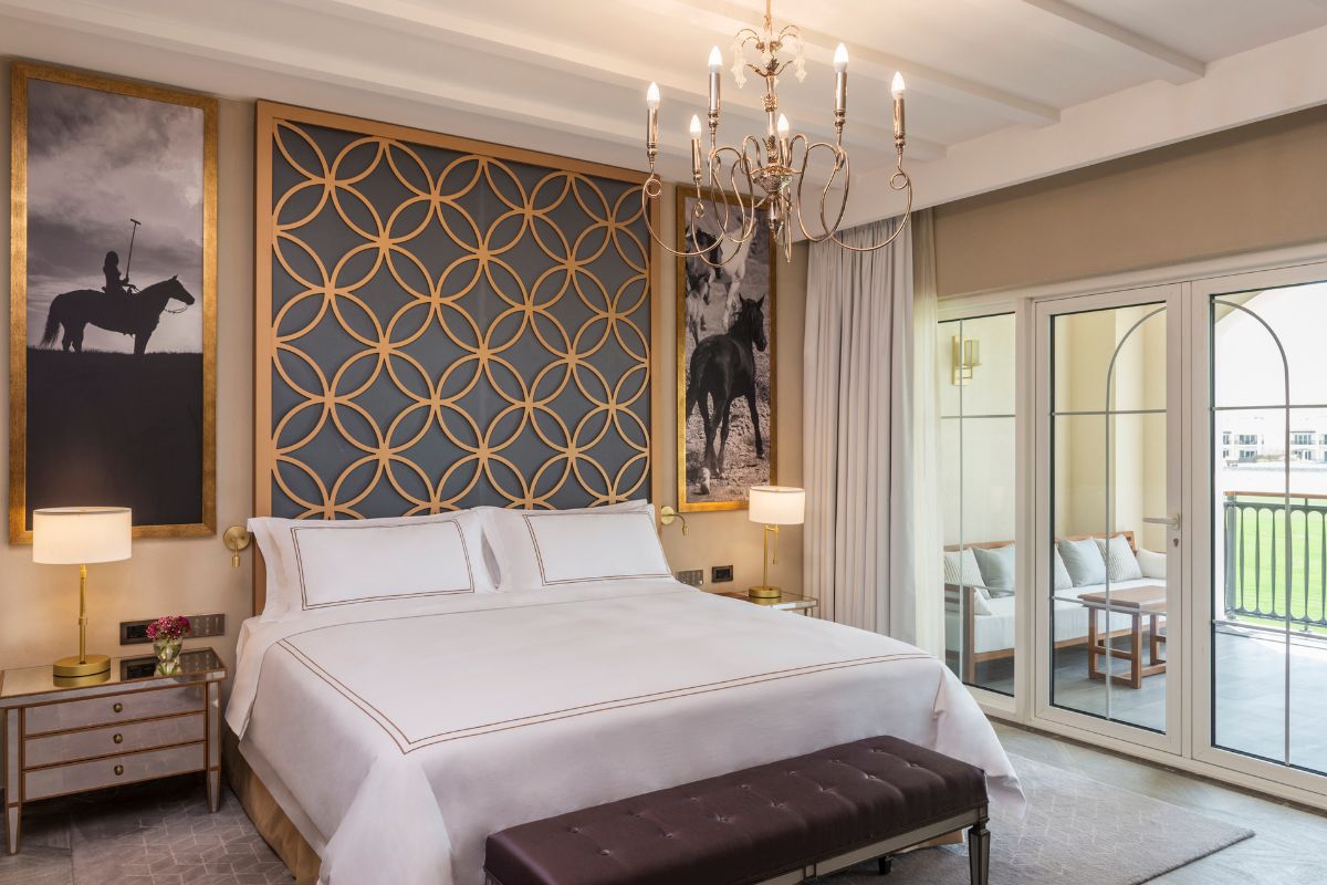 Executive Suite - Bed With Table Side And Table Lamp. On Ceiling There'S Chandelier. On Balcony, There'S Table And Chairs At Al Habtoor Polo Resort Staycation