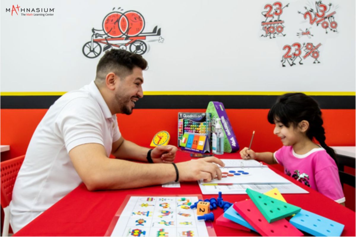 A Tutor And A Kid Learning Math At Camp Mathnasium Summer Camp In Dubai
