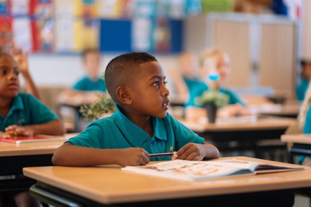 A kid listening to his teaching during class, back to school