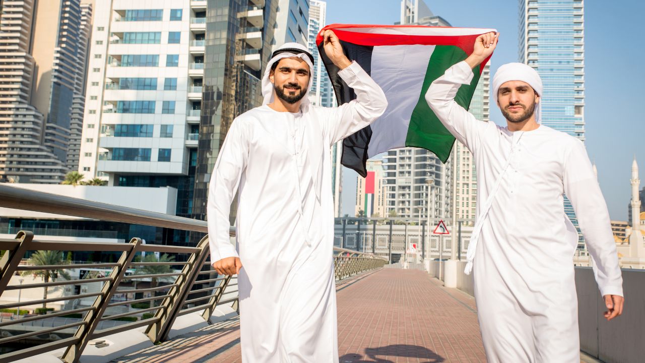 People walking around dubai holding flag