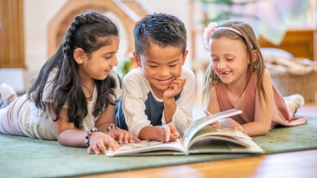 Children reading a book together, enjoying learning and playtime at home.