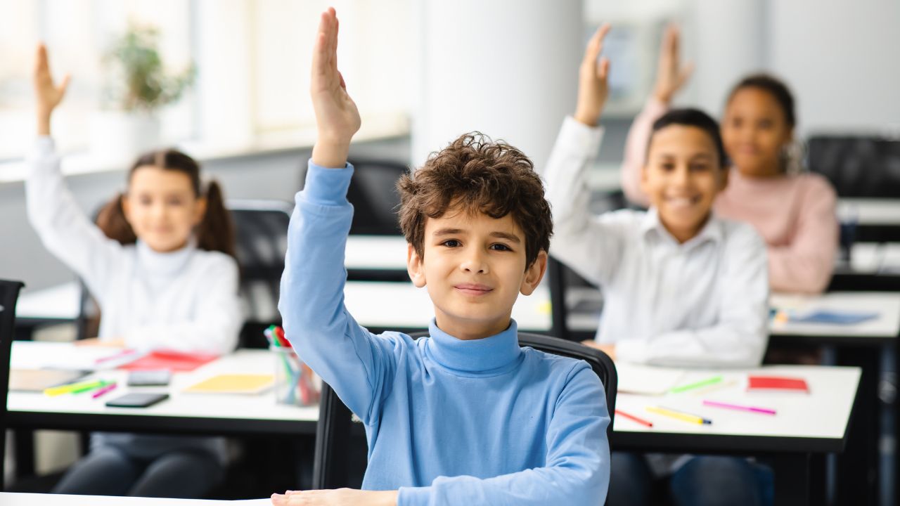 students in class raising their hand