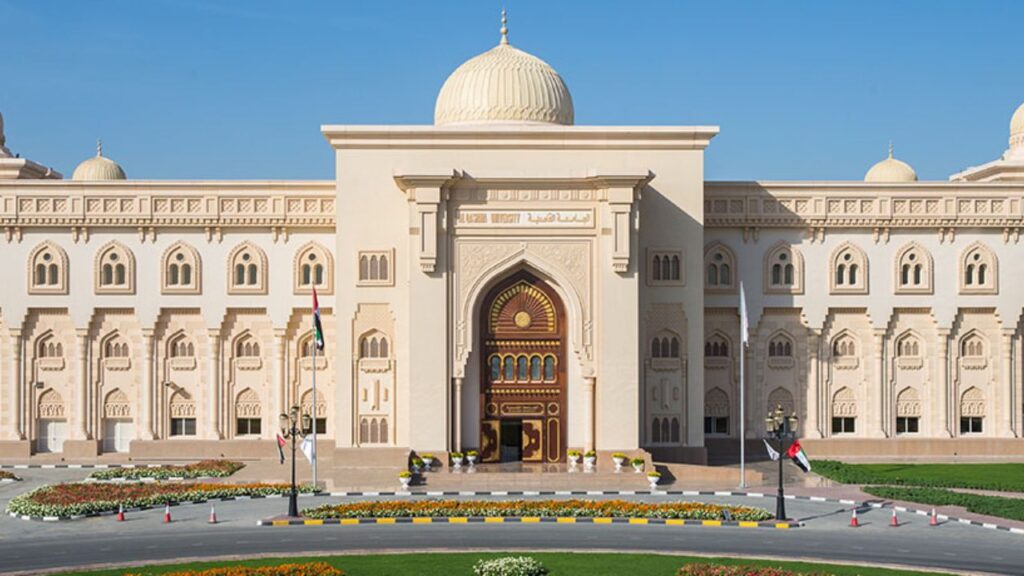 Al Qasimia University main entrance with traditional Islamic architecture, white façade, and decorat.