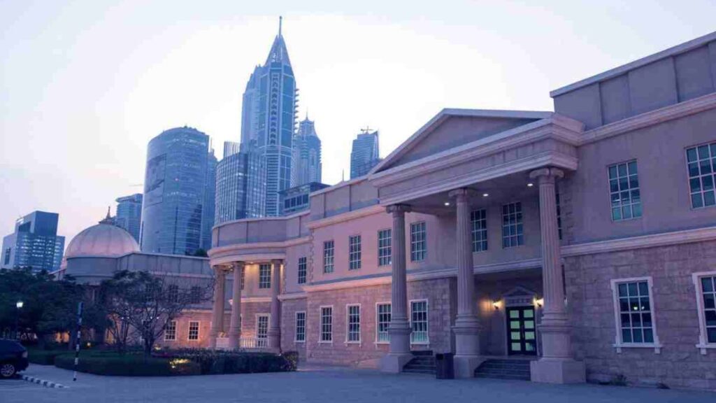 Iconic view of the American University in Dubai with Dubai's skyline in the background.