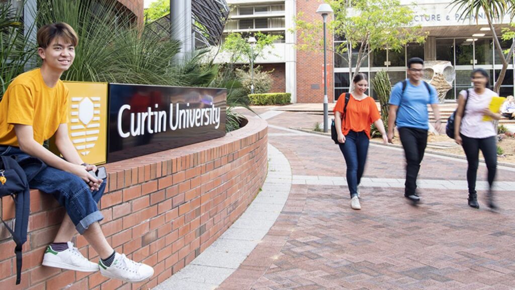 Students walking near Curtin University Dubai campus entrance.