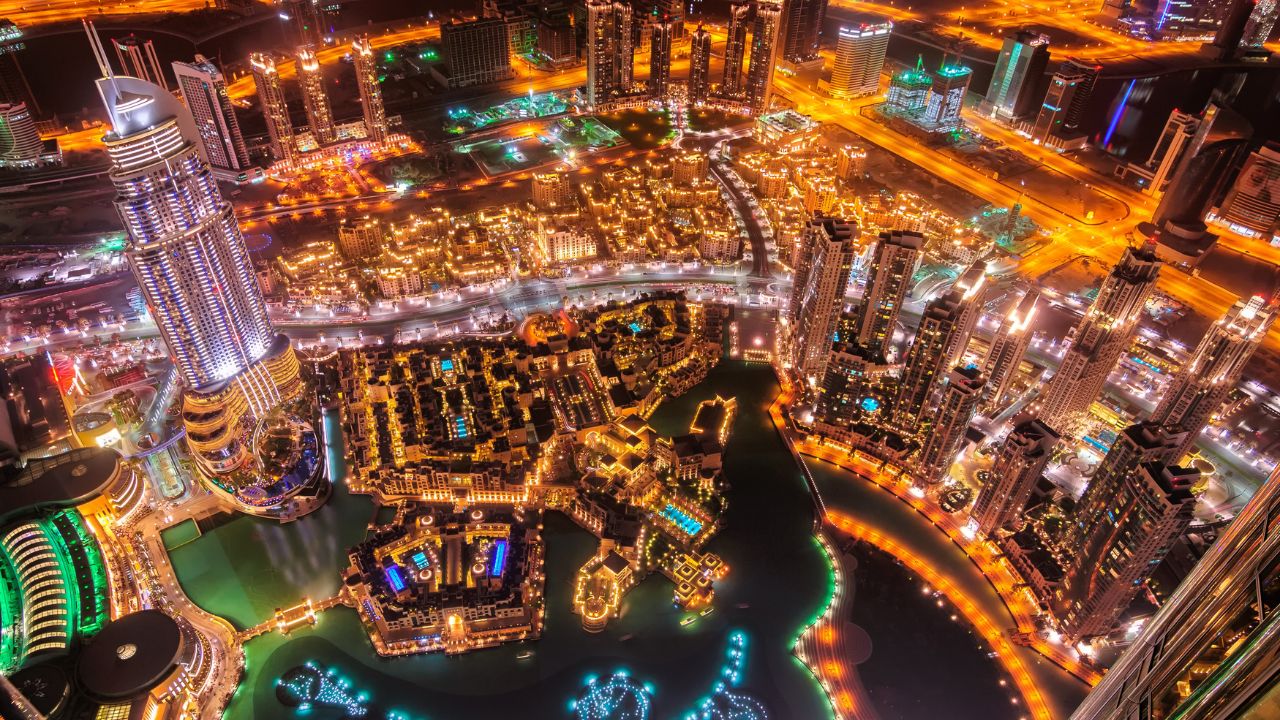 Dubai skyline at night with illuminated skyscrapers and waterways. Night view of Dubai's illuminated skyline and waterways during New Year’s Eve.