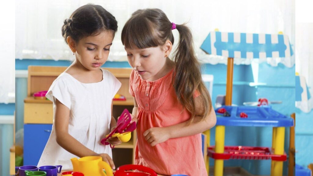 Two young girls playing with toys at Tappy Toes Nursery, Dubai.