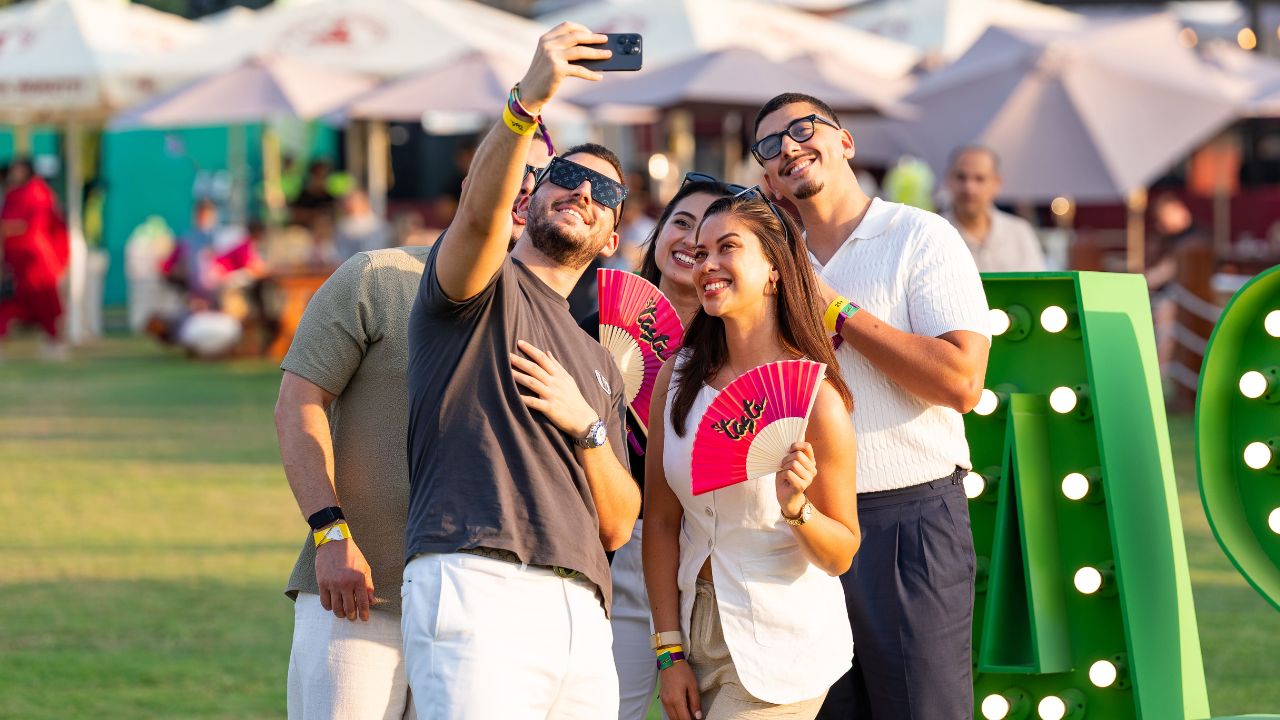 Yalla Dubai Life at Taste of Dubai Enjoy friends taking selfies at Taste of Dubai event in vibrant outdoor setting.