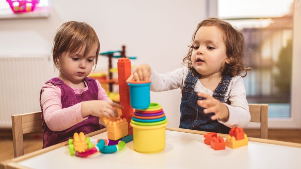 Two young children playing with colourful toys at a Dubai nursery.