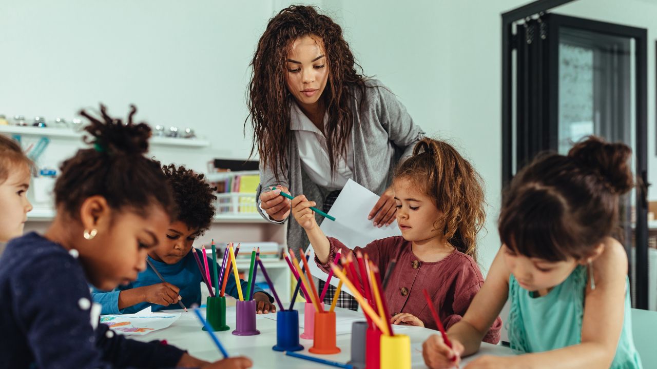 teacher helping her students in art class