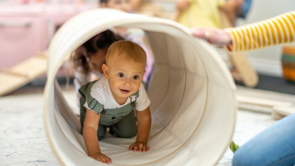 Child crawling through a play tunnel at an indoor activity centre in Dubai.