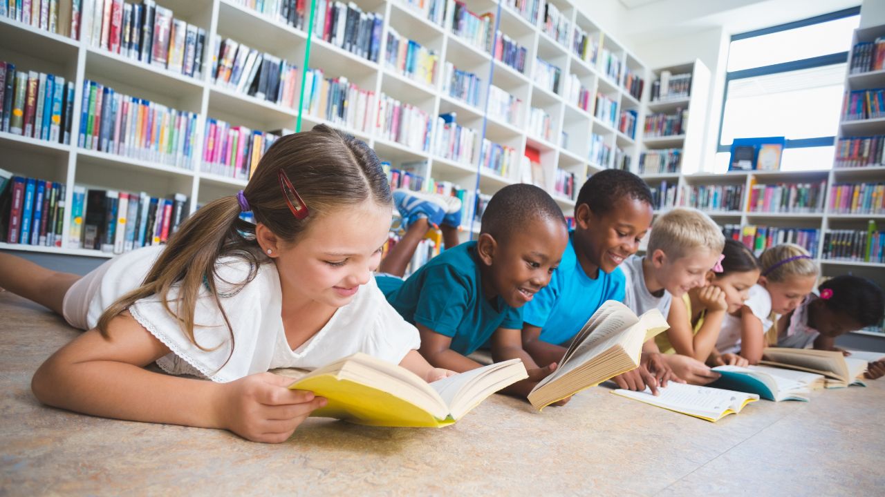 Children reading books in a library, promoting online learning for kids in the UAE.