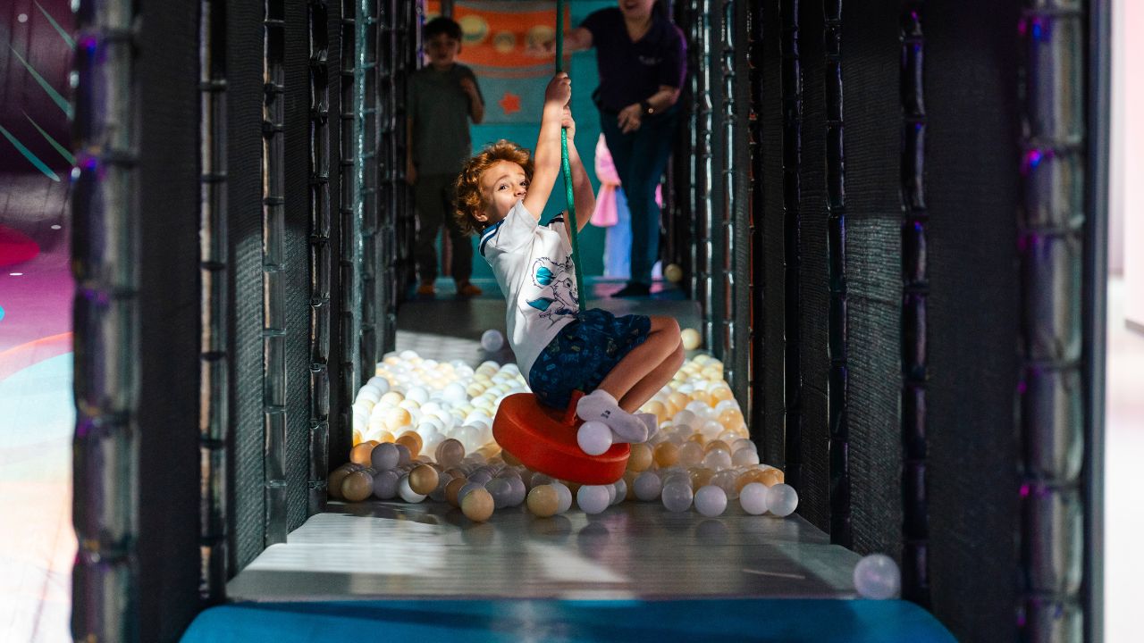Child enjoying a swing in an indoor play zone in Dubai.