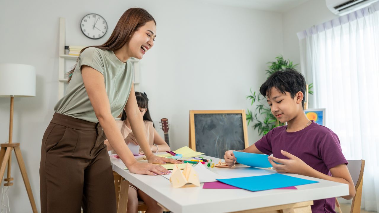 Friendly tutor helping student with homework at home.
