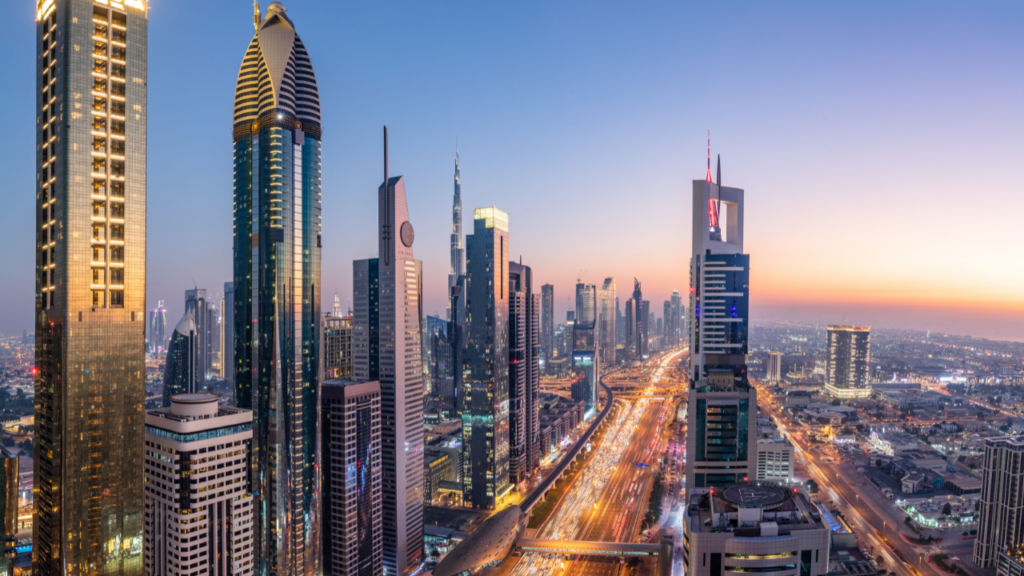 This shot captures a breathtaking view of a sprawling cityscape filled with modern high-rise buildings. Captured during sunrise or sunset, the buildings are illuminated with the warm glow of the sun.