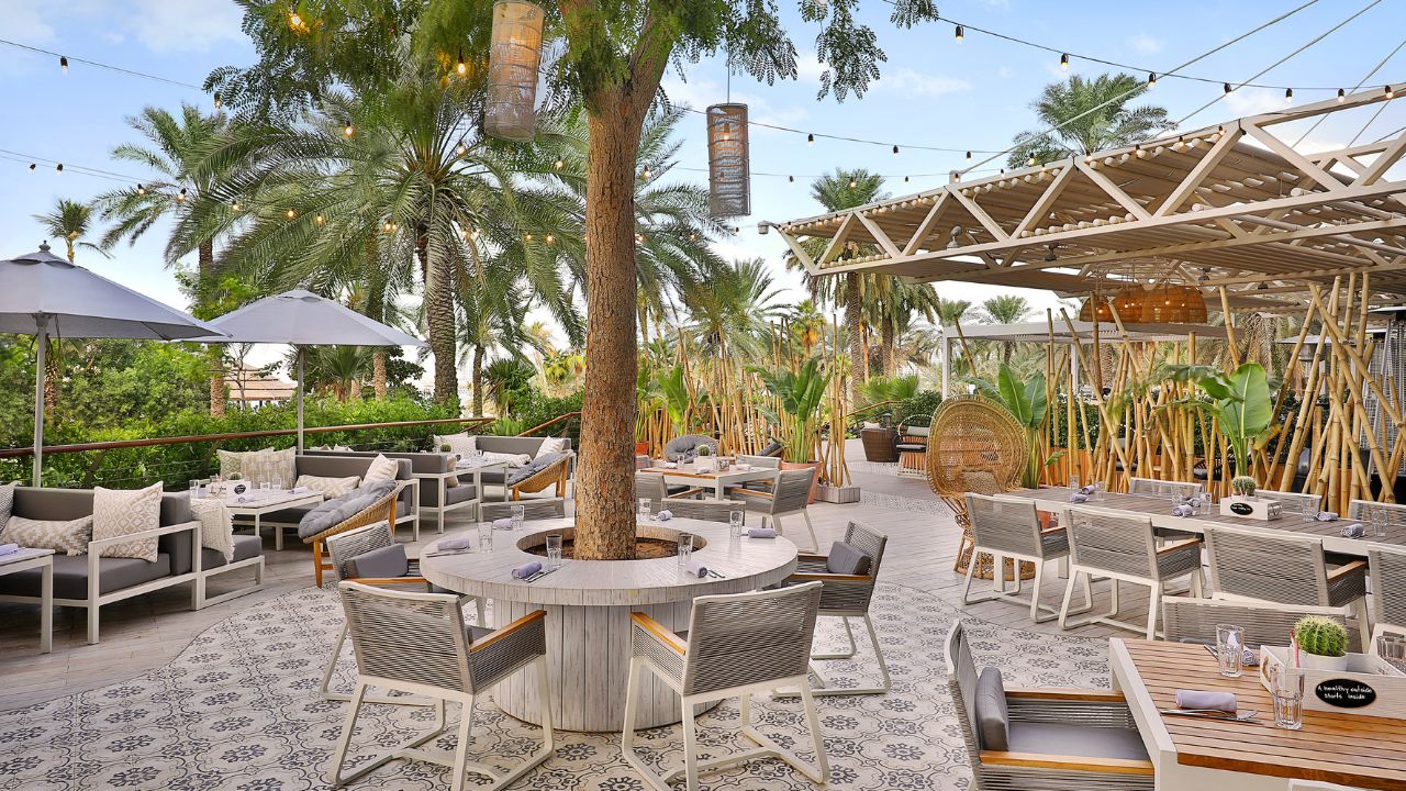 Relaxed outdoor community event space in Dubai with seating and greenery. Le Méridien Mina Seyahi Beach Resort & Waterpark