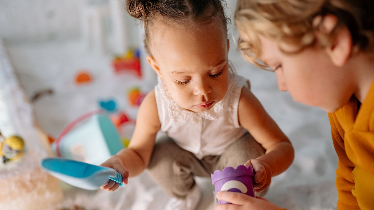 Two children playing with sand toys at a Dubai nursery or home education setting.