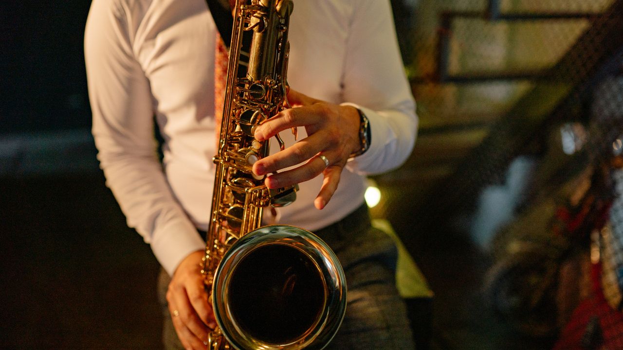 A saxophonist playing and pressing the buttons