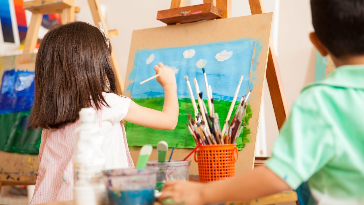 Creative children painting outdoors in a bright art studio. kids painting together