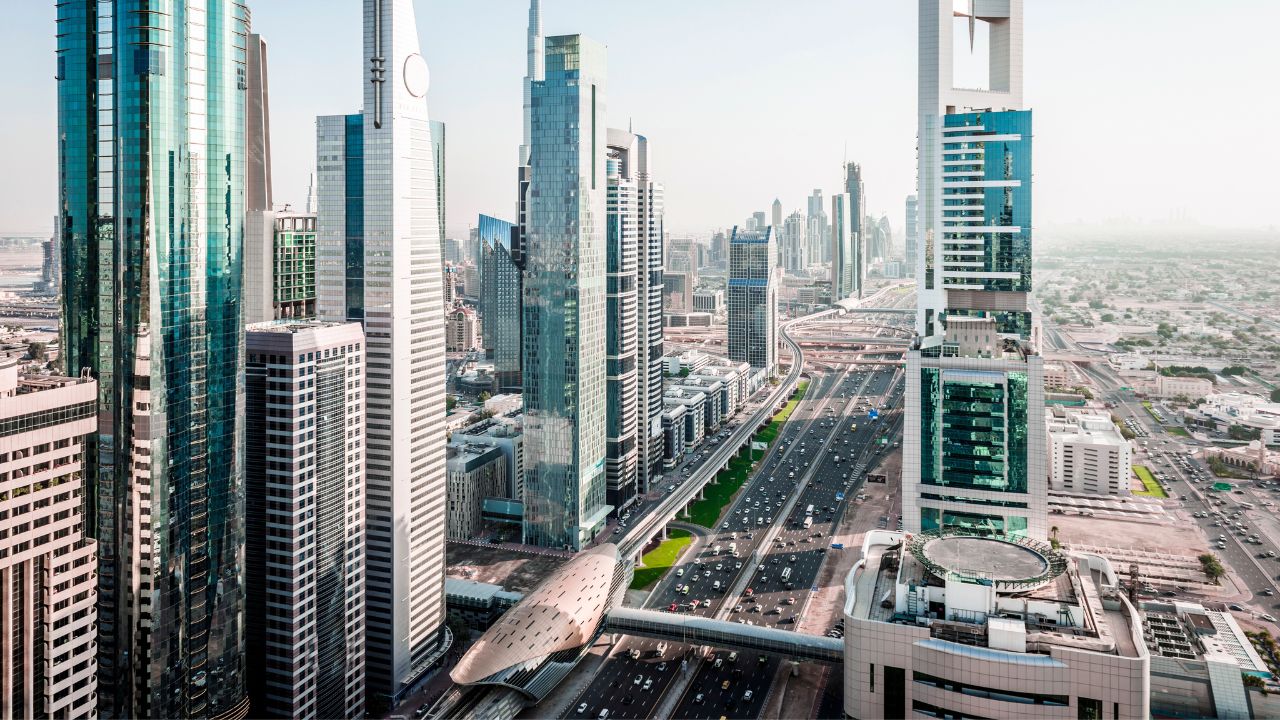 Aerial view of Dubai's modern skyscrapers and busy roads.
