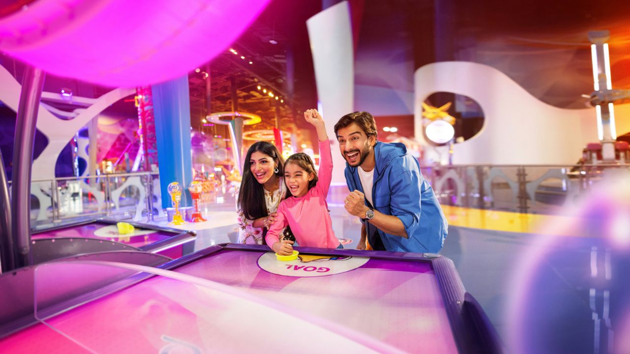 family playing an airhockey machine