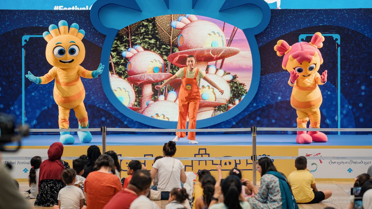 people performing on stage with children watching them