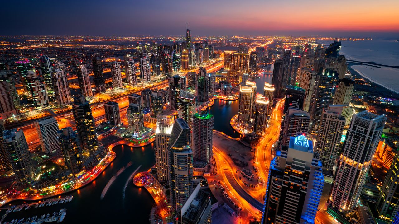 Stunning Dubai cityscape illuminated at night with skyscrapers and waterways.