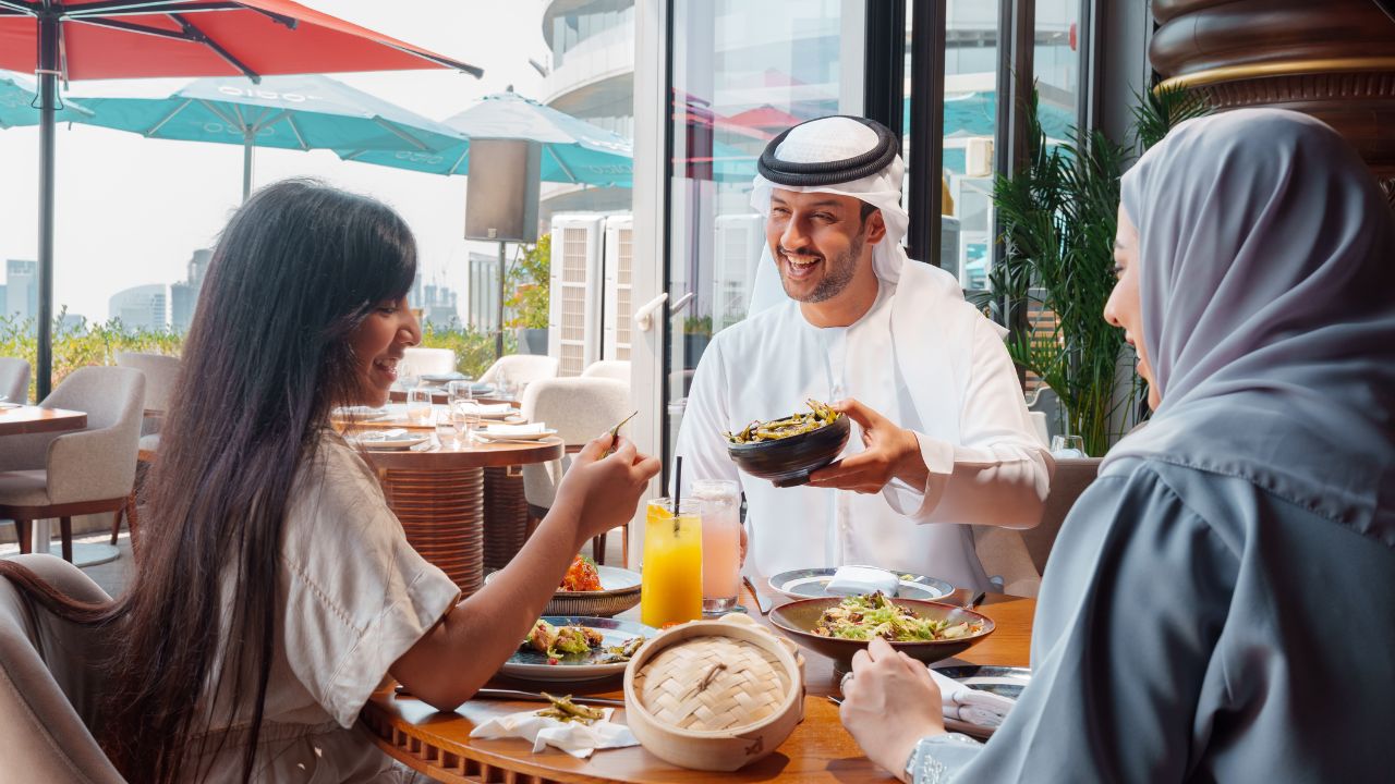 Happy diners enjoying Middle Eastern cuisine at a Dubai restaurant during summer.