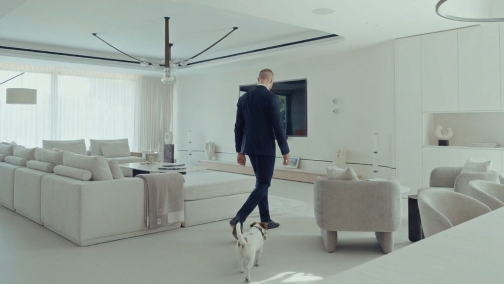 Stylish modern living room with man walking dog, bright and spacious interior.