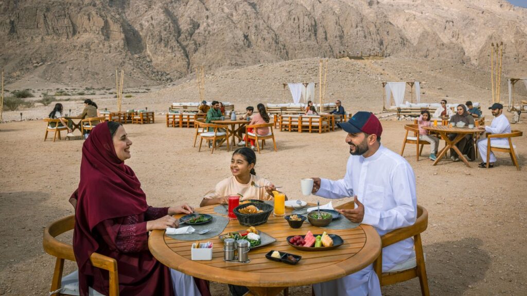 Family enjoying meal at outdoor desert restaurant in Al Ain.