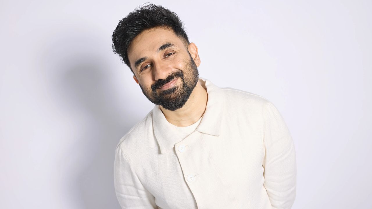 Smiling man with beard in white shirt, promoting Dubai comedy events.