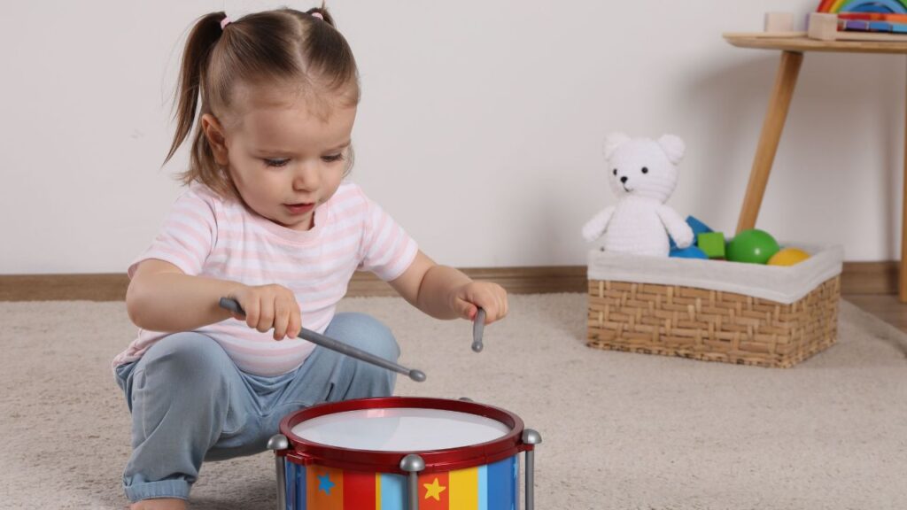 little girl playing drums