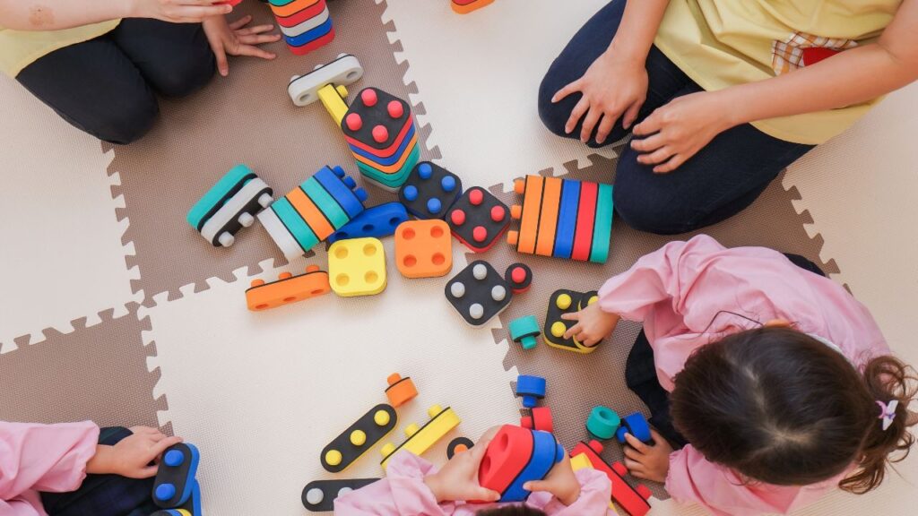 kids huddled in a circle playing with toys