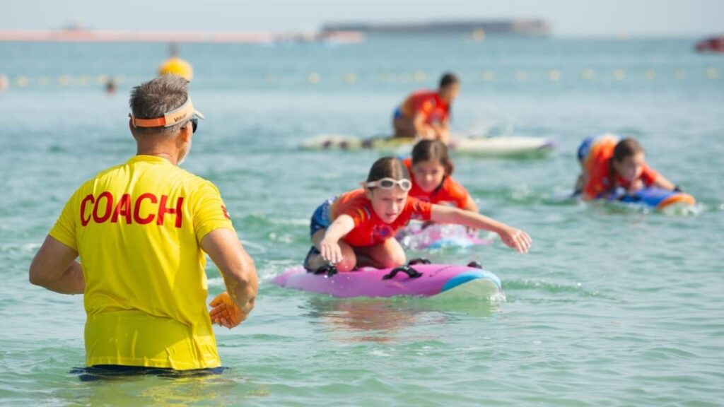 A coach/lifeguard on standby while the kids are in the water