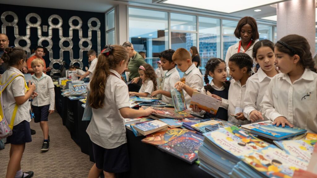 Students with a guardian gather around a table full of books
