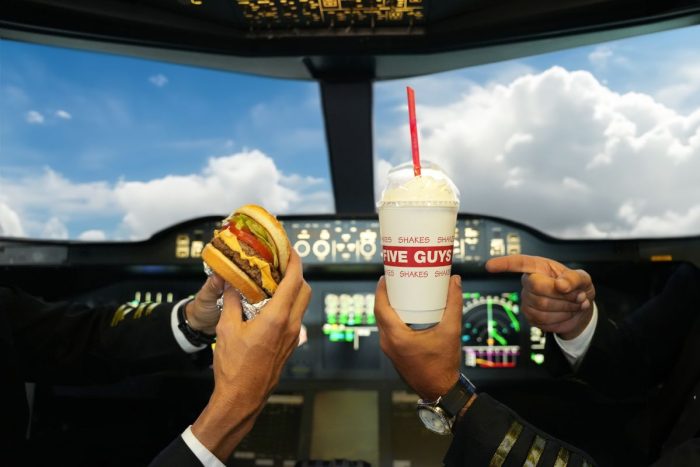 1 Guy Is Holding Five Guys Burger And Shake In An Airplane