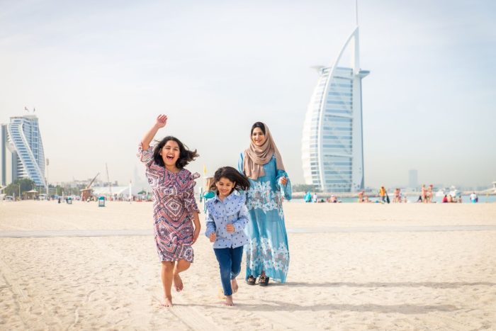 A family running on the beach at Burj Al Arab