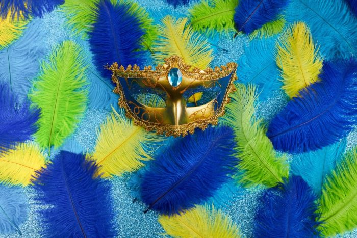 A mardi gras mask under feather boas for the Butterfly Carnival in Dubai this 2024