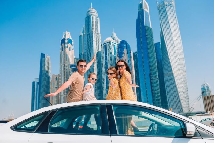 A family of four on top of a car in Dubai for the best things to do in Dubai this August