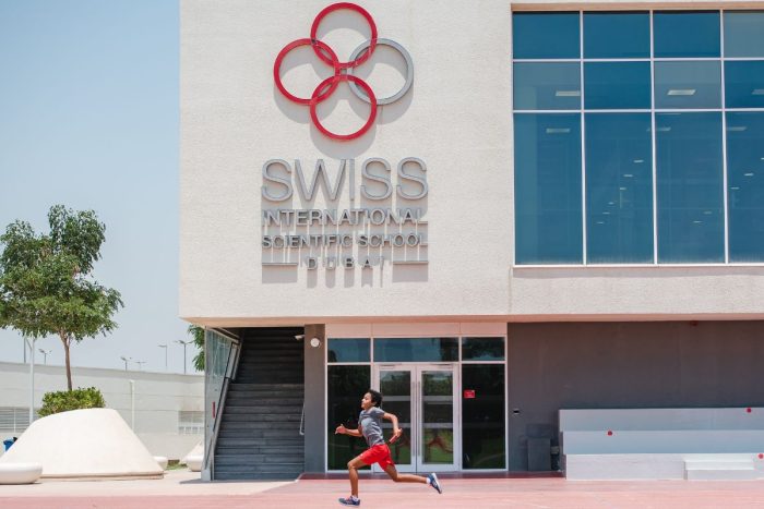 A kid running in front of Swiss International Scientific School Dubai